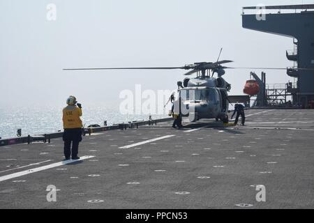 U.S. 5ÈME ZONE DES OPÉRATIONS DE LA FLOTTE (sept. 4, 2018) l'aviation d'équipage (manutention) 2e classe Sarah Briley signaux pour maintenir l'avion sur le pont tandis que maîtres d'aviation' Mate (manipulation), Sarah Jones et Airman Christian Pannell caler et la chaîne à bord de l'USS Lewis B. Extracteur (ESB 3). La base maritime expéditionnaire plate-forme prend en charge La Naval Amphibious Force, Task Force 51, 5e Marine Expeditionary brigade des missions diverses qui comprennent l'intervention en cas de crise, la lutte contre les mines, les opérations de lutte contre la piraterie, les opérations de sécurité maritime et de l'aide humanitaire et des secours en cas de catastrophe, tout en permettant aux missions à TF 51/5 Banque D'Images