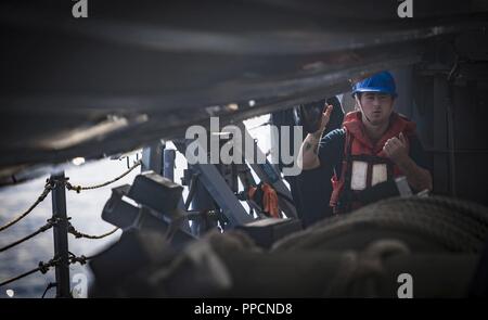 Mer (Aug. 29, 2018) Maître de Manœuvre de 3e classe Michael Sisolak soulève une embarcation pneumatique à coque rigide à bord de la classe Arleigh Burke destroyer lance-missiles USS Carney (DDG 64) Le 29 août 2018. Carney, l'avant-déployé à Rota, en Espagne, est sur sa cinquième patrouille dans la sixième flotte américaine zone d'opérations à l'appui d'alliés et de partenaires régionaux ainsi que les intérêts de sécurité nationale des États-Unis en Europe et en Afrique. Banque D'Images