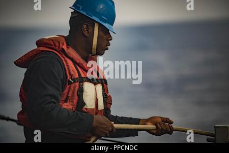 Mer (Aug. 29, 2018) Maître de Manœuvre Matelot-Tabiq Doolin gère une ligne de stabilité à bord de la classe Arleigh Burke destroyer lance-missiles USS Carney (DDG 64) Le 29 août 2018. Carney, l'avant-déployé à Rota, en Espagne, est sur sa cinquième patrouille dans la sixième flotte américaine zone d'opérations à l'appui d'alliés et de partenaires régionaux ainsi que les intérêts de sécurité nationale des États-Unis en Europe et en Afrique. Banque D'Images