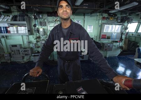 Océan Atlantique (16 août 2000 29, 2018) Maître de Manœuvre Seaman Erick Anderson mans la barre du navire à bord du destroyer lance-missiles USS Arleigh Burke (DDG 51). Arleigh Burke est actuellement déployé dans le cadre de la Harry S. Truman Strike Group. Harry S. Truman continuera son déploiement en menant des opérations de soutien dans l'Atlantique. Banque D'Images