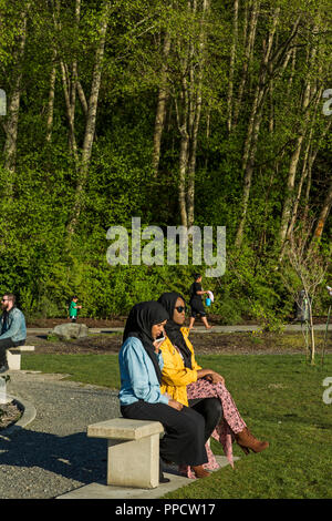 Deux femmes portant un hijab assis sur un banc de parc, Seattle, Washington, USA Banque D'Images