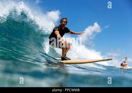 L'homme et la jeune femme surf sur vague éclaboussant, homme, Maldives Banque D'Images