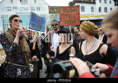 Les jeunes en robe de soirée style vintage manifester devant la gare Pasinger contre l'embourgeoisement. La photo montre des signes avec l'inscription "condamner les entreprises familiales" et "Golf au lieu de construction sociale'. Banque D'Images