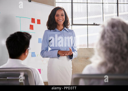 Mixed Race businesswoman donnant une présentation lors d'une réunion Banque D'Images