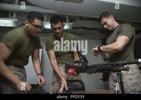 Golfe d'ADEN - Marines des États-Unis Lance Cpl. Ceasr Lua, l'explosion d'une missleman, lance le Cpl. Julio Ortiz, faisant valoir un, et le Cpl. Henning, également une subvention, faisant valoir toutes les armes avec l'entreprise, l'équipe d'atterrissage bataillon 3/1, 13e Marine Expeditionary Unit (MEU), sont comptabilisés lors de l'assemblage d'une mitrailleuse M-240B à bord de la classe Wasp-navire d'assaut amphibie USS Essex (DG 2), le 4 septembre 2018. L'Essex est le navire amiral de la Essex Groupe amphibie et, avec l'entrepris 13e MEU, est déployé sur le 5e flotte américaine zone d'opérations à l'appui des opérations navales pour assurer la stabilité et la sécurité maritime je Banque D'Images