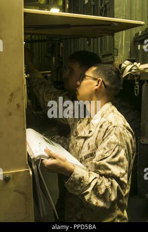 Golfe d'ADEN - Marines des États-Unis Lance Cpl. Brandon Toledo, un administrateur réseau, et lance le Cpl. Connor Moryn, un administrateur réseau, à la fois avec l'Équipe de débarquement du bataillon 3/1, 13e Marine Expeditionary Unit (MEU), brancher la communication couronne dans un Humvee, à bord de la classe Wasp-navire d'assaut amphibie USS Essex (DG 2), le 4 septembre 2018. L'Essex est le navire amiral de la Essex Groupe amphibie et, avec l'entrepris 13e MEU, est déployé sur le 5e flotte américaine zone d'opérations à l'appui des opérations navales pour assurer la stabilité et la sécurité maritime dans la région Centrale, reliant la Medite Banque D'Images