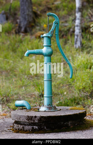 Vintage vert main exploité au-dessus de la pompe à eau de son bien. Banque D'Images