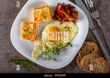 Œuf frit frit avec du fromage, du beurre et quelques cornichons sur la plaque - Vue de dessus Banque D'Images