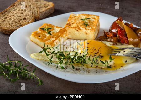 Œuf frit frit avec du fromage, du beurre et quelques cornichons sur la plaque - vue rapprochée Banque D'Images