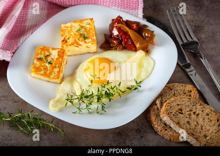 Œuf frit frit avec du fromage, du beurre et quelques cornichons sur la plaque - Vue de dessus Banque D'Images