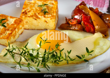 Œuf frit frit avec du fromage, du beurre et quelques cornichons sur la plaque - vue rapprochée Banque D'Images