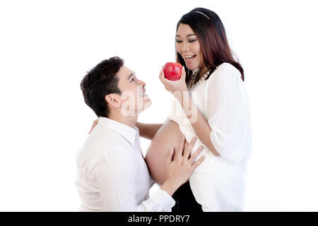 Man looking at his pregnant wife holding apple Banque D'Images