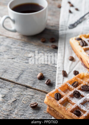 Gaufres Belges viennois doux avec du sucre en poudre et les grains de café sur fond de bois rustique. Banque D'Images