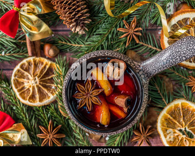 Vin chaud de Noël à la cannelle, d'orange et d'anis étoilé dans un bol en céramique avec des décorations d'hiver. Banque D'Images