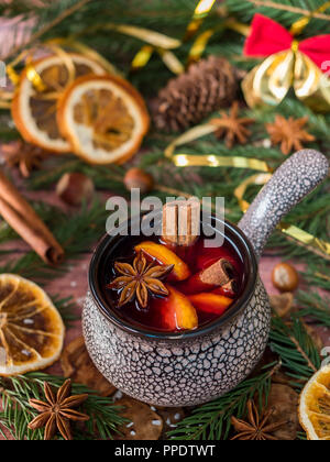 Vin chaud de Noël à la cannelle, d'orange et d'anis étoilé dans un bol en céramique avec des décorations d'hiver. Banque D'Images