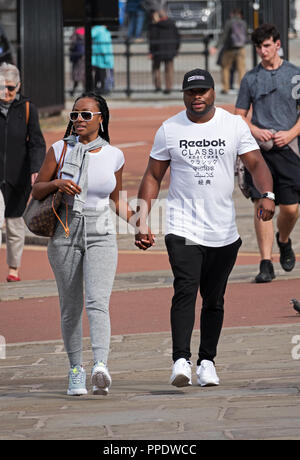 Jeune black couple holding hands tandis que dehors la marche. Banque D'Images