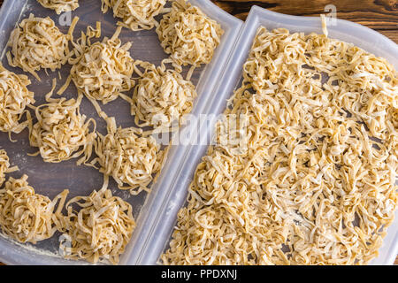 Faire des pâtes fettuccine dans une vue de dessus de nouilles ruban fraîchement coupé le séchage sur deux plateaux de cuisine en plastique dans une saine Mediterranea Banque D'Images