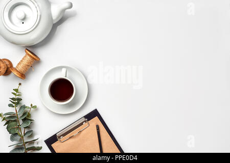 Nature morte à la tasse de thé et le contenu d'un document composé. Différents objets sur le tableau blanc. Mise à plat. Vue d'en haut. Copy space Banque D'Images