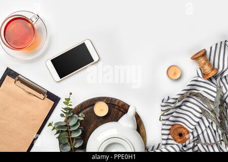 Nature morte à la tasse de thé et le contenu d'un document composé. Différents objets sur le tableau blanc. Mise à plat. Vue d'en haut. Copy space Banque D'Images