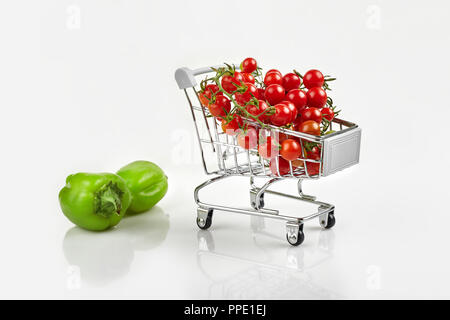 Panier plein de tomates, poivre sur fond blanc. Copy space Banque D'Images