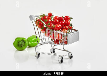 Panier plein de tomates, poivre sur fond blanc. Copy space Banque D'Images