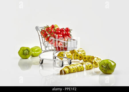 Panier plein de tomates, poivre sur fond blanc. Copy space Banque D'Images