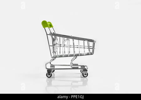Close up of Supermarket Grocery push cart pour le shopping avec roues noires sur fond blanc. Concept de shopping. Mini chariot plein Banque D'Images