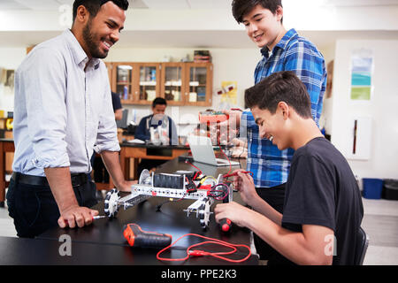 Avec l'enseignant Les élèves masculins robotique Bâtiment Véhicule en Leçon de science Banque D'Images