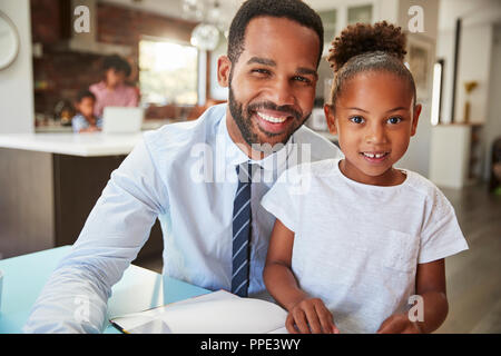 Portrait of Father Reading Book avec sa fille avant de se rendre au travail Banque D'Images