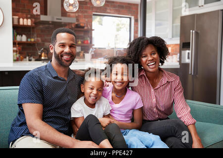 Portrait Of Family Relaxing On Sofa At Home Together Banque D'Images