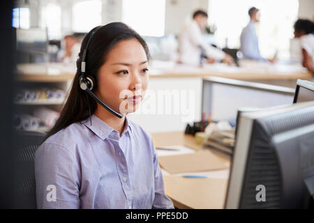 Young Asian woman travaillant dans un centre d'appel Banque D'Images