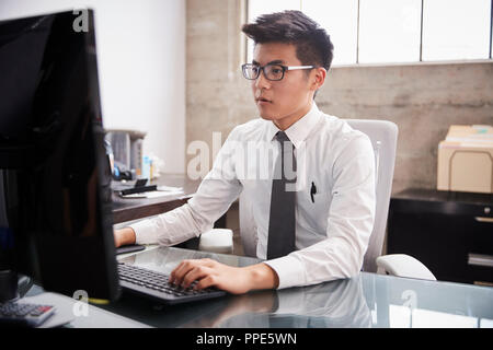 Young Asian Woman à l'aide d'un ordinateur à un bureau bureau Banque D'Images