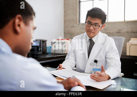 Les jeunes hommes asiatiques médecin en consultation avec male patient Banque D'Images