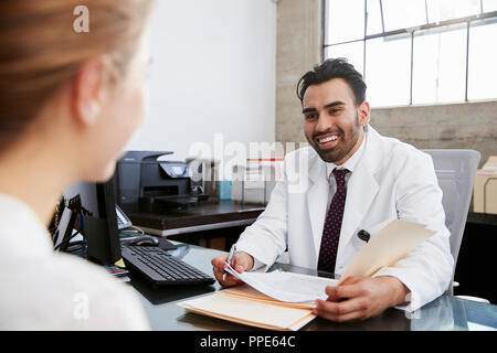 Hispanic male doctor en consultation with female patient Banque D'Images