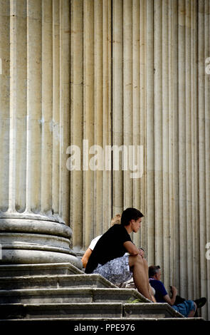 Les gens assis sur les marches, entre les colonnes de la Staatliche Antikensammlungen (état des collections d'Antiquités) sur Koenigsplatz à Munich. Banque D'Images