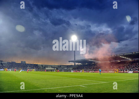 Poursuivi en Regionalliga derby : FC Bayern Munich II (en rouge) - TSV 1860 München (2-0) dans le stade municipal dans l'Gruenwalder Strasse à Munich. Dans l'arrière-plan Bayern fans enflammer la pyrotechnie. Banque D'Images