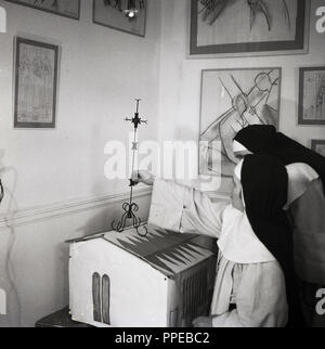 1950, deux religieuses catholiques dans une salle avec des croquis sur les murs et avec une maquette de la Chapelle du Rosaire de Vence. La construction de la chapelle sur la Côte d'Azur est un projet conçu et décoré par l'artiste Henri Matisse vers la fin de sa vie et qui est considéré par le peintre lui-même comme son dernier chef-d'œuvre. Banque D'Images