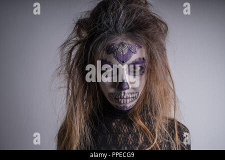 Portrait d'une fille avec un terrible masque sur son visage. Maison de l'Halloween. Banque D'Images