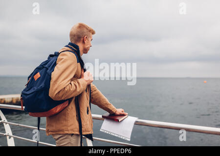 College student avec sac à dos et réserve de marche par la mer après les classes et admirant vue sur plage à Odessa. Jeune homme pensant Banque D'Images