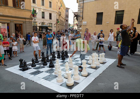 Personnes jouant aux échecs en plein air sur un échiquier géant, Piazza Salimbeni, Sienne, Toscane Italie Europe Banque D'Images