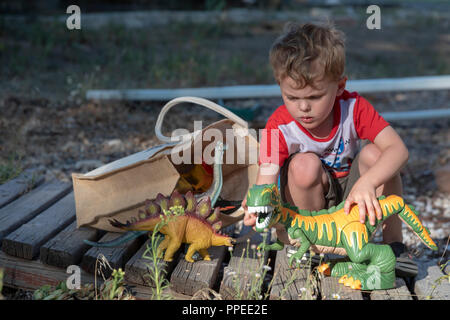 Aspen, Colorado - Adam Hjermstad, 4, joue avec son jouet dinosaures. Banque D'Images