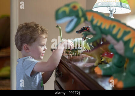 Aspen, Colorado - Adam Hjermstad, 4, joue avec son jouet dinosaures. Banque D'Images