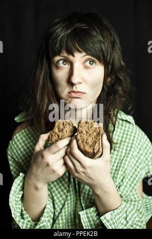 Portrait d'un pauvre mendiant woman eating bread Banque D'Images