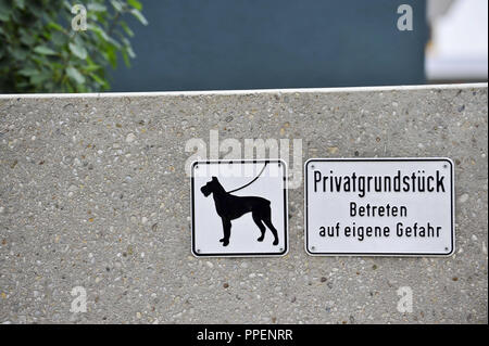 La lecture des panneaux 'laisse pour les chiens" et "Ventes privées - Entrez à vos propres risques" sur le mur d'une propriété dans la région de Munich. Banque D'Images