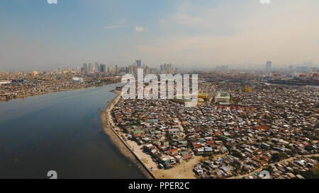 Vue aérienne du quartier défavorisé de bidonvilles de Manille, des ghettos, de vieilles maisons en bois, cabanes. Bidonville de Manille, aux Philippines. Banlieue de Manille, vue depuis l'avion. Banque D'Images