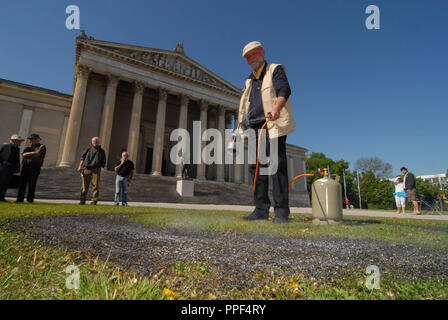 L'artiste Wolfram Kastner commémore la brûler sur le livre 1933 Koenigsplatz à Munich. Il grave un cercle symbolique dans l'herbe sur le site où le 10 mai 1933 les œuvres d'éminents écrivains ont été brûlés par les Nazis. En outre, une lecture est tenu de l'œuvres concernées. Banque D'Images