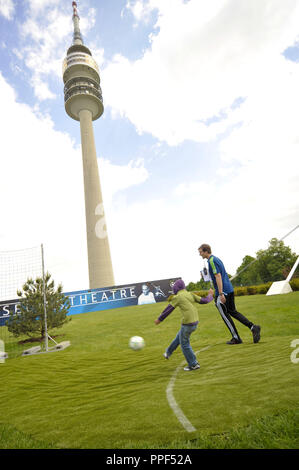 Le festival des champions dans l'Olympiapark avant la finale de la Ligue des Champions FC Bayern contre Chelsea FC. Quatre jours de festival de football pour tous les habitants de Munich ! La photo montre un homme et un garçon quand des coups de la balle. Dans l'arrière-plan, la Tour Olympique. Banque D'Images