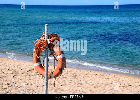 Bouée orange dans la plage de sable en face de la mer méditerranée, bouée de sauvetage avec corde sur la plage Banque D'Images