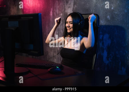 Portrait d'une jeune fille heureuse qui se réjouit après avoir remporté un jeu vidéo, - une célébration qui gagne dans l'émotion de jeu concept. Banque D'Images