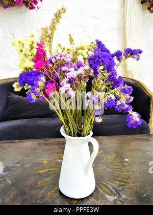 Composition de belles fleurs séchées dans un vase blanc sur une vieille table Banque D'Images